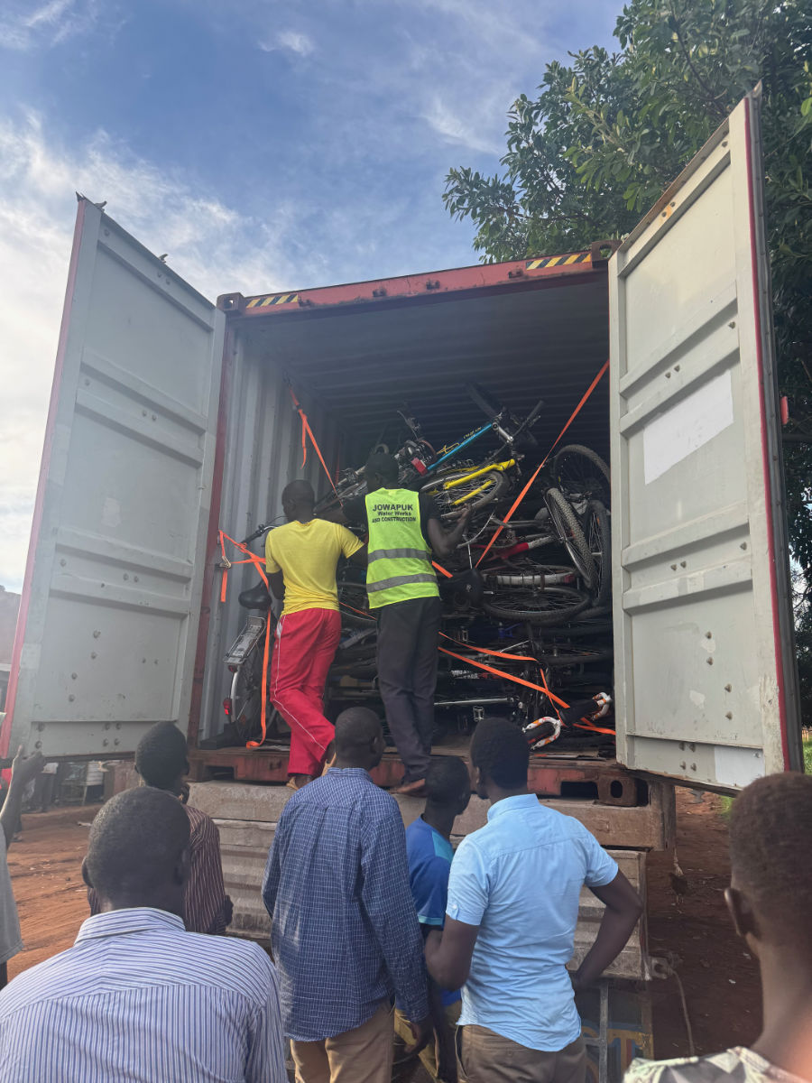 Mehrere Personen schauen in den geöffneten Container bei dessen Ankunft.