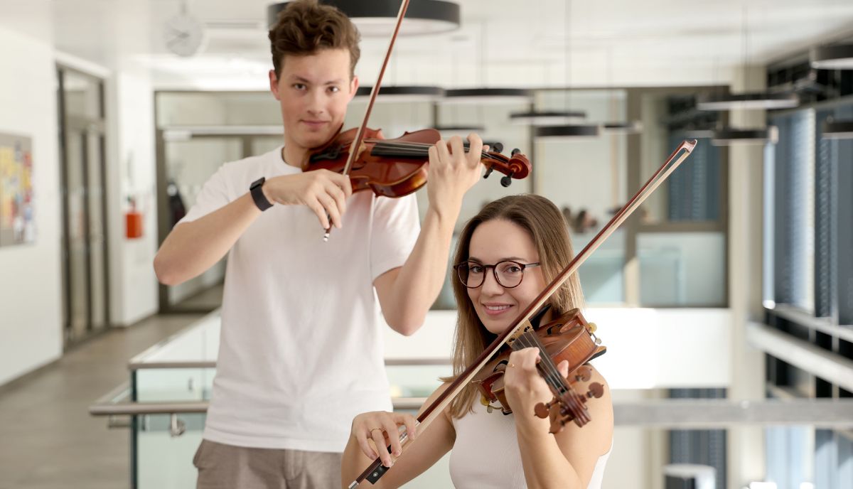 Theresa Nagel und Leander Ruchti mit ihren Geigen im Med Uni Gebäude